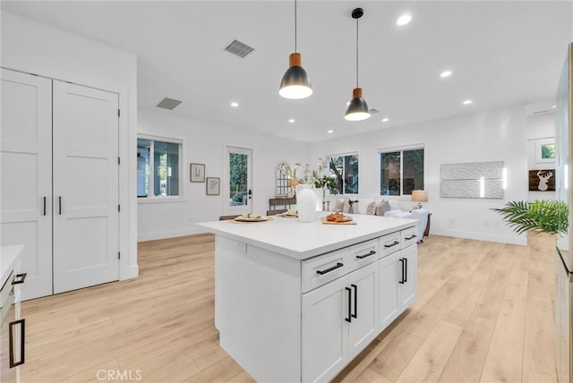 kitchen with light wood-type flooring, white cabinetry, visible vents, and recessed lighting