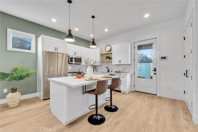 kitchen featuring open shelves, appliances with stainless steel finishes, light wood-style flooring, and white cabinetry