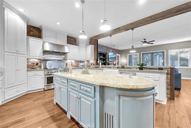 kitchen featuring white cabinets, light wood-style flooring, a kitchen island with sink, stainless steel appliances, and under cabinet range hood