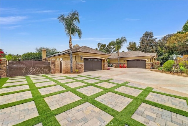 view of front facade with concrete driveway, stone siding, an attached garage, a gate, and fence