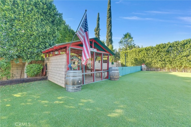 view of poultry coop featuring a fenced backyard and a lawn