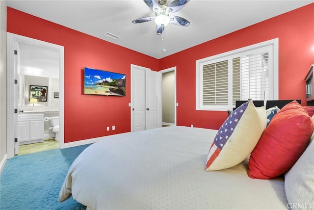 bedroom featuring carpet floors, visible vents, ensuite bathroom, ceiling fan, and baseboards