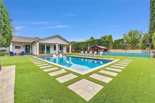 view of swimming pool with a patio area, a fenced in pool, fence, and a lawn