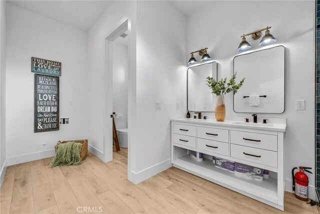 2480 Oak Ave, Corona, CA 92882 - bathroom with wood finished floors, double vanity, and baseboards