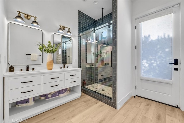 2480 Oak Ave, Corona, CA 92882 - bathroom featuring a shower stall, double vanity, wood finished floors, and plenty of natural light