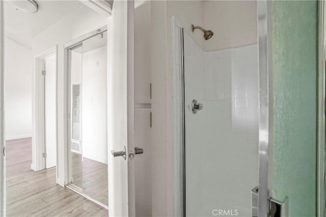 bathroom featuring wood finished floors and walk in shower