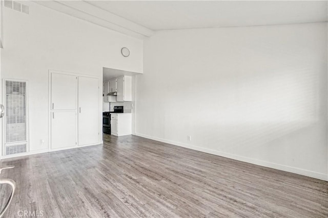 unfurnished room featuring visible vents, beam ceiling, high vaulted ceiling, wood finished floors, and baseboards