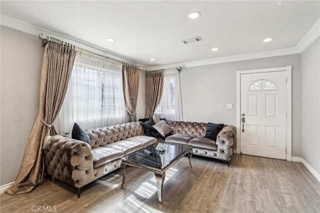 living area with light wood finished floors, recessed lighting, visible vents, ornamental molding, and baseboards