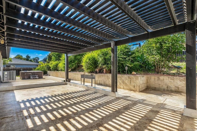 view of patio / terrace featuring a pergola, fence, and a hot tub