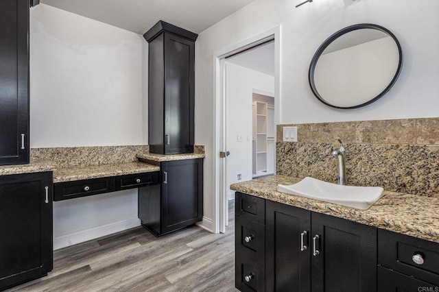 bathroom with backsplash, vanity, and wood finished floors