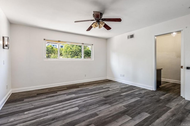 unfurnished room with ceiling fan, dark wood-type flooring, visible vents, and baseboards