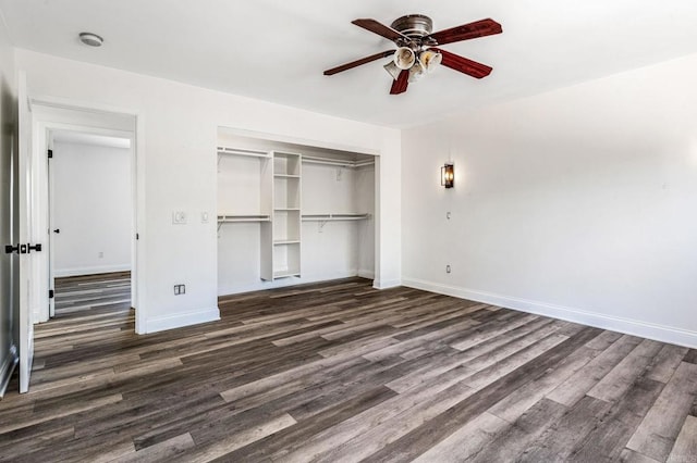 unfurnished bedroom with a closet, dark wood finished floors, and baseboards