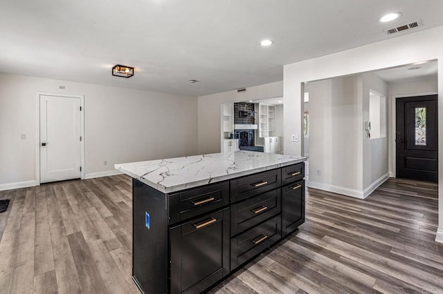 kitchen with dark cabinets, visible vents, baseboards, and wood finished floors