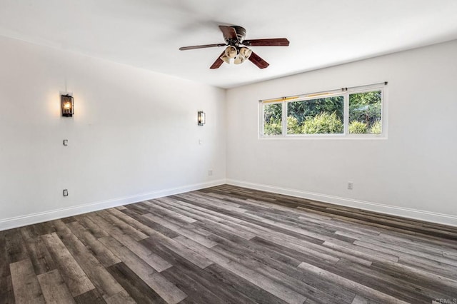 spare room featuring dark wood-style flooring, ceiling fan, and baseboards