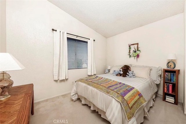 bedroom featuring vaulted ceiling, carpet floors, and a textured ceiling