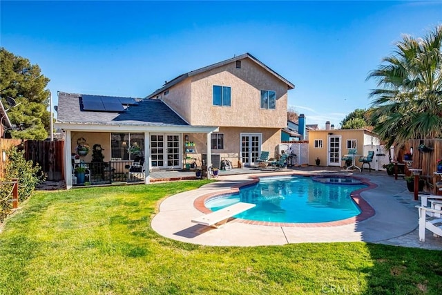 view of pool with french doors, a fenced backyard, a lawn, and a patio