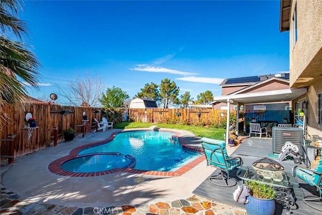 view of swimming pool with a fenced backyard, a pool with connected hot tub, and a patio