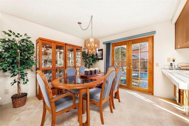 dining area with light carpet, french doors, and a notable chandelier