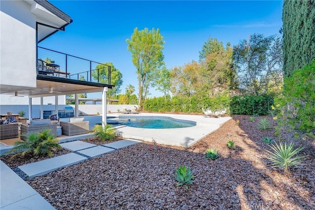 view of pool featuring a fenced in pool, a patio, fence, and an outdoor hangout area