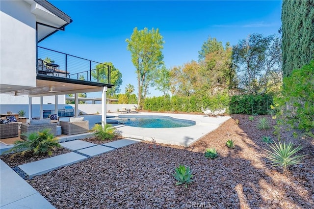 view of pool featuring an outdoor living space, a patio area, and a fenced in pool