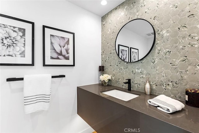 bathroom with a sink, decorative backsplash, recessed lighting, and visible vents