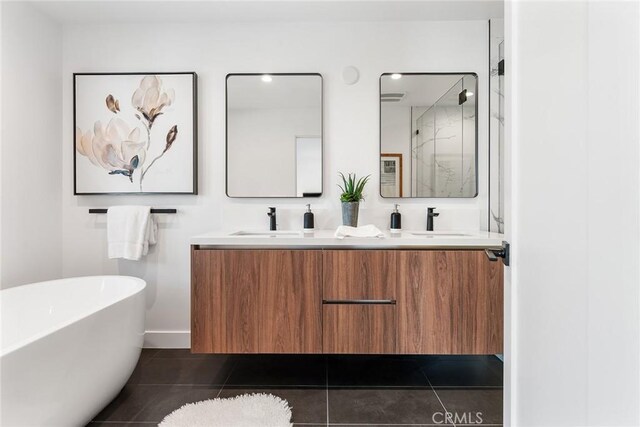 bathroom featuring tile patterned flooring, a sink, a soaking tub, double vanity, and a stall shower