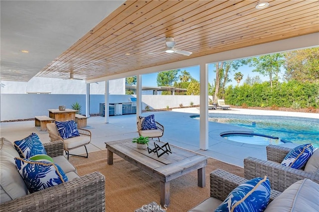 view of patio / terrace featuring a fenced in pool, a hot tub, fence, exterior kitchen, and an outdoor living space