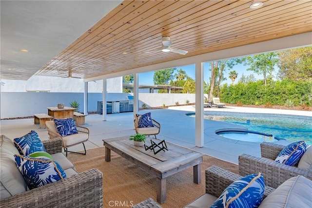 view of patio / terrace featuring ceiling fan, fence, an outdoor hangout area, a fenced in pool, and a hot tub