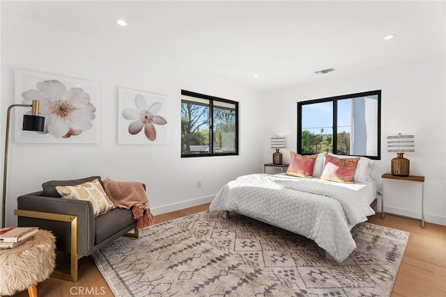 bedroom with light wood-style flooring, recessed lighting, multiple windows, and visible vents