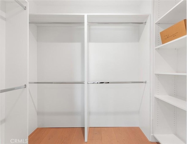 walk in closet with wood finished floors