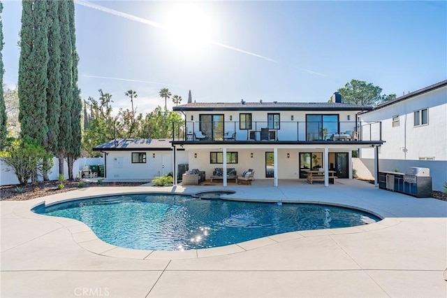 back of house featuring a balcony, outdoor lounge area, fence, an outdoor pool, and a patio area