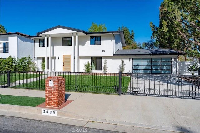 view of front facade with a fenced front yard, decorative driveway, stucco siding, a front yard, and a garage