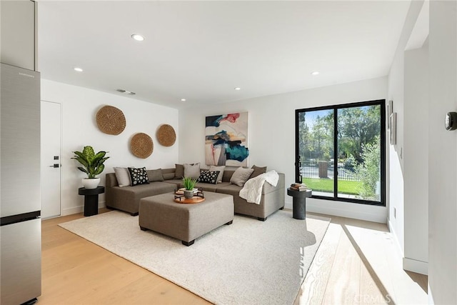 living area with light wood-type flooring, visible vents, and recessed lighting