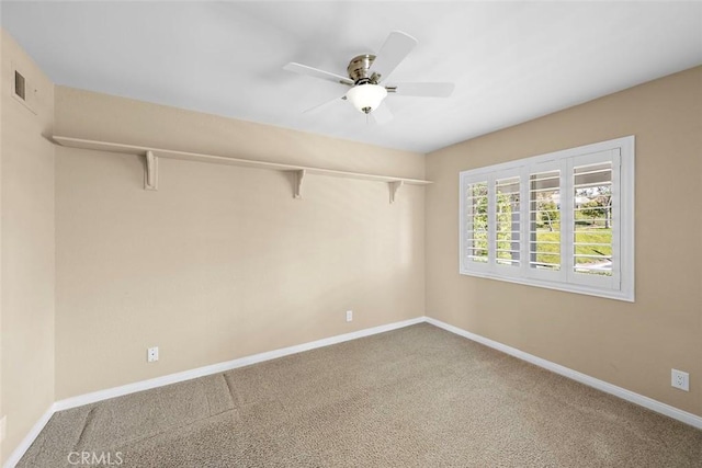 carpeted empty room with visible vents, a ceiling fan, and baseboards