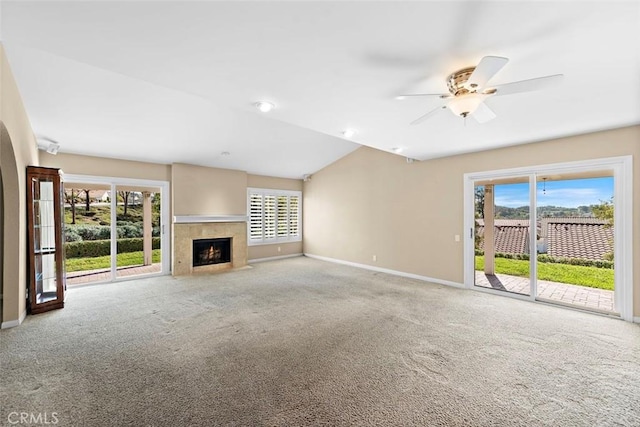 unfurnished living room with a fireplace with flush hearth, baseboards, ceiling fan, and carpet flooring