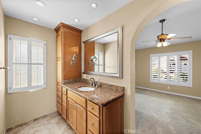 bathroom with plenty of natural light, baseboards, a ceiling fan, and vanity