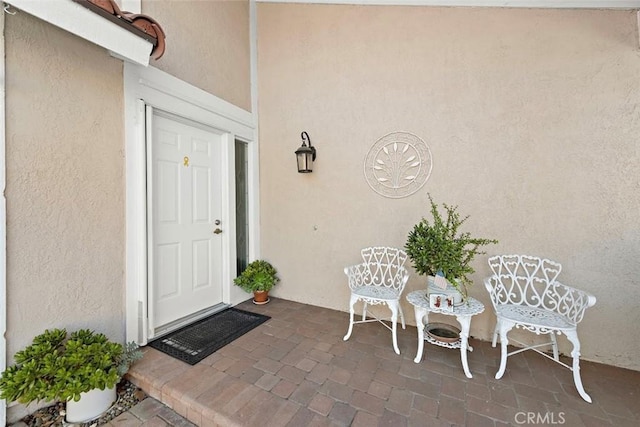 property entrance with a patio and stucco siding