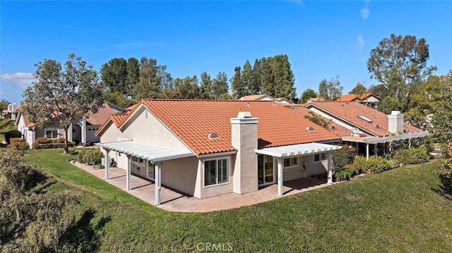 rear view of property featuring a tiled roof, a yard, a patio area, and stucco siding