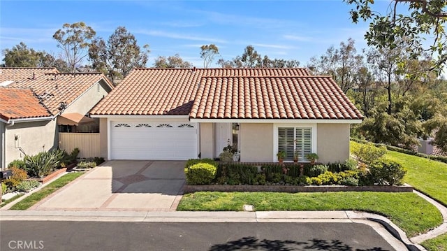 mediterranean / spanish-style house with driveway, an attached garage, a tile roof, and stucco siding