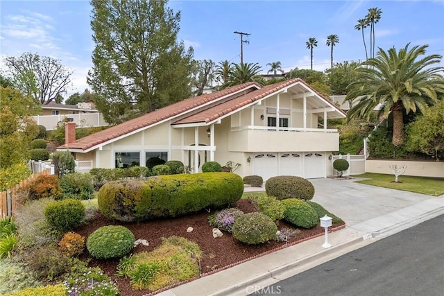 view of front of property with fence, driveway, an attached garage, and stucco siding