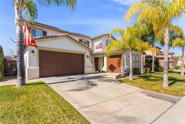 mediterranean / spanish home featuring an attached garage, driveway, a tiled roof, stucco siding, and a front lawn