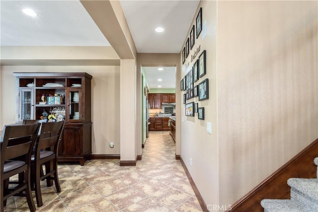 corridor with recessed lighting, baseboards, and stairs