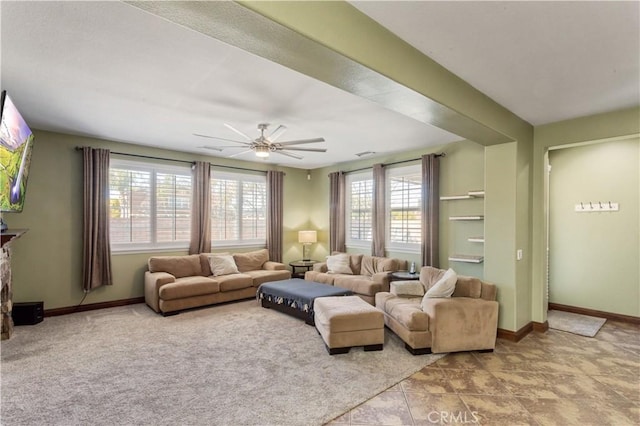 living room with visible vents, a ceiling fan, and baseboards