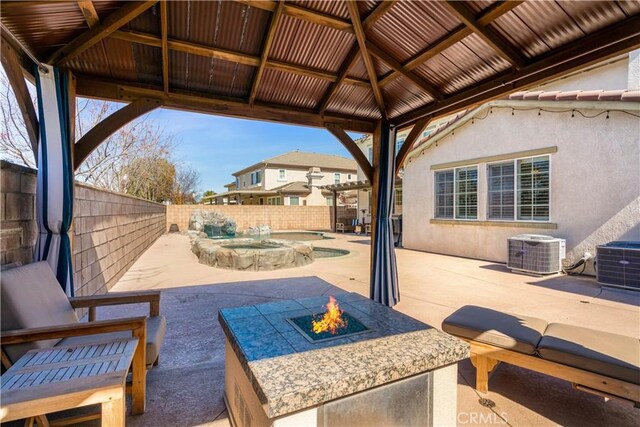 view of patio with an outdoor fire pit, a fenced backyard, central air condition unit, a gazebo, and a fenced in pool