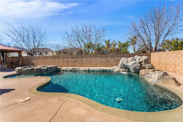 view of pool featuring a patio area, a fenced backyard, a pool with connected hot tub, and a gazebo