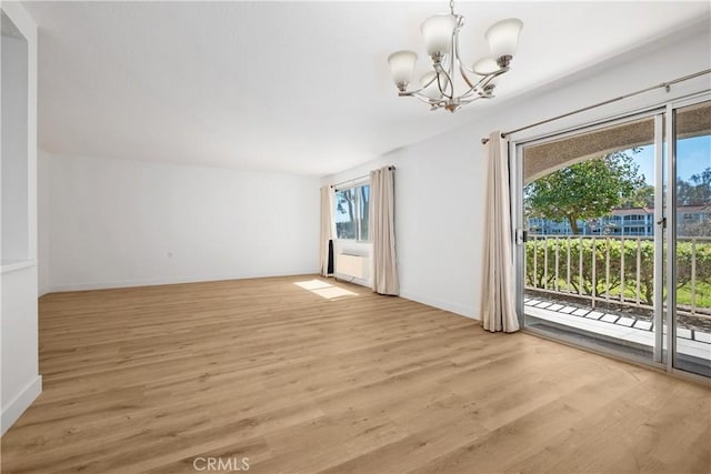 interior space featuring an inviting chandelier, light wood finished floors, and baseboards