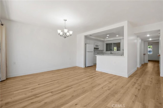 4012 Calle Sonora Oeste Unit 1B, Laguna Woods, CA 92637 - unfurnished living room with a chandelier, light wood-style flooring, recessed lighting, and a tray ceiling