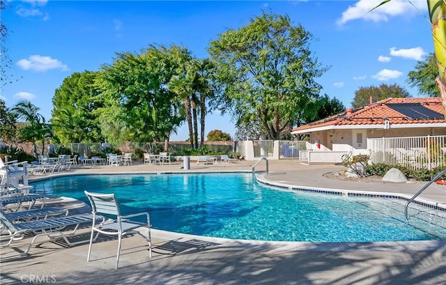 community pool featuring fence and a patio