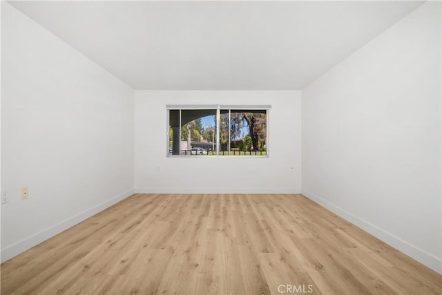 unfurnished room with light wood-type flooring and baseboards