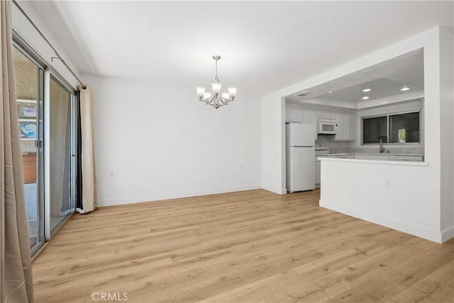 4012 Calle Sonora Oeste Unit 1B, Laguna Woods, CA 92637 - kitchen featuring white appliances, a chandelier, light countertops, light wood-style flooring, and white cabinetry